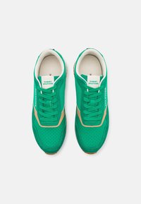 Pari di sneakers verdi Tommy Hilfiger con accenti beige, punta perforata e rivestimento interno bianco, viste dall'alto.