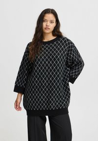 Pull en tricot noir avec un motif en losanges de couleur bleu clair. Coupe surdimensionnée avec des manches trois-quarts et un col côtelé.