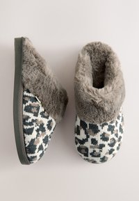 Chaussons tricotés avec un motif léopard, dotés d'un col gris duveteux. La semelle est gris foncé, avec un design à bout arrondi.