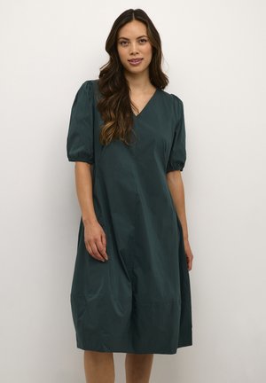 Abito midi teal con scollo a V, maniche corte a sbuffo e silhoutte rilassata. Realizzato in tessuto morbido e leggero con cuciture minime.