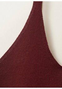Burgundy knit bralette with a textured finish and thin straps, featuring a triangular shape and subtle stitching detail along the edges.
