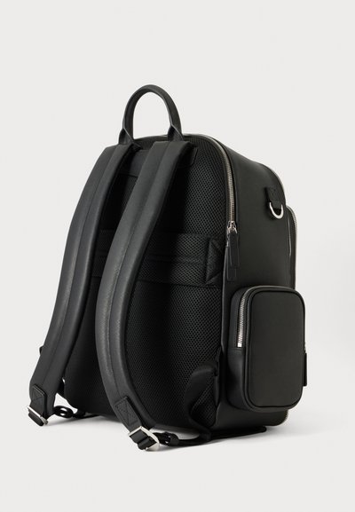 Sac à dos noir avec bretelles rembourrées, une poignée sur le dessus, un panneau arrière en maille, un compartiment principal zippé et une poche frontale zippée.