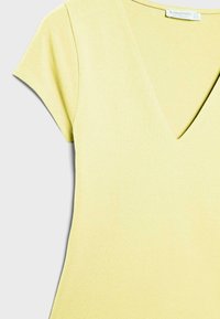 T-shirt a maniche corte color giallo pallido con scollo a V, taglio aderente e etichetta Stradivarius all'interno del collo.