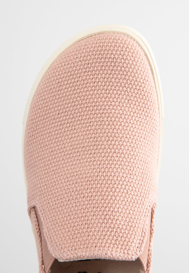 Hellrose Slip-On-Schuh mit strukturiertem Obermaterial und cremefarbener Sohle. Mit runder Zehenpartie und elastischen Seitenpanelen für ein einfaches Anziehen.
