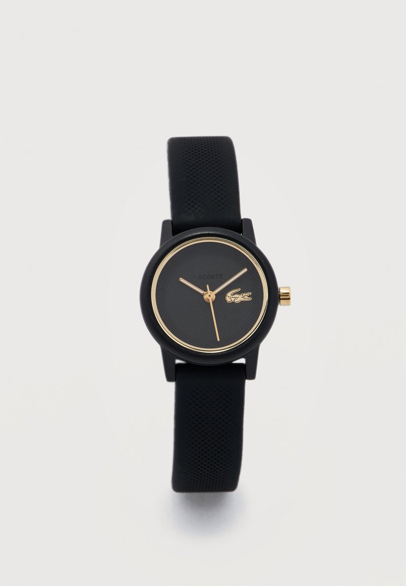 Ceas de mână negru cu accente aurii, curea texturată și logo de crocodil pe cadran, care indică ora aproximativ 10:10:34.