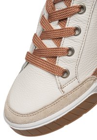 Sneaker in pelle bianca con lacci marroni testurizzati, dettagli in suede e suola in gomma. Presenta occhielli metallici e cuciture dettagliate.