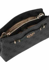 Schwarze Stoffhandtasche mit strukturiertem Muster, goldenen Hardware-Akzenten, doppelten Reißverschlussfächern und geprägt Logo. Das Innere ist beige.