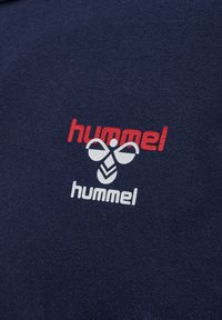 Marinblå bomulls-T-shirt med en röd och vit logotyp med en bi och text. Mjuk känsla med en klassisk rundad halsringning.