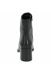 Botín negro de piel con un acabado suave, cierre de cremallera y tacón apilado. Presenta un logotipo grabado en el costado y puntera redondeada.