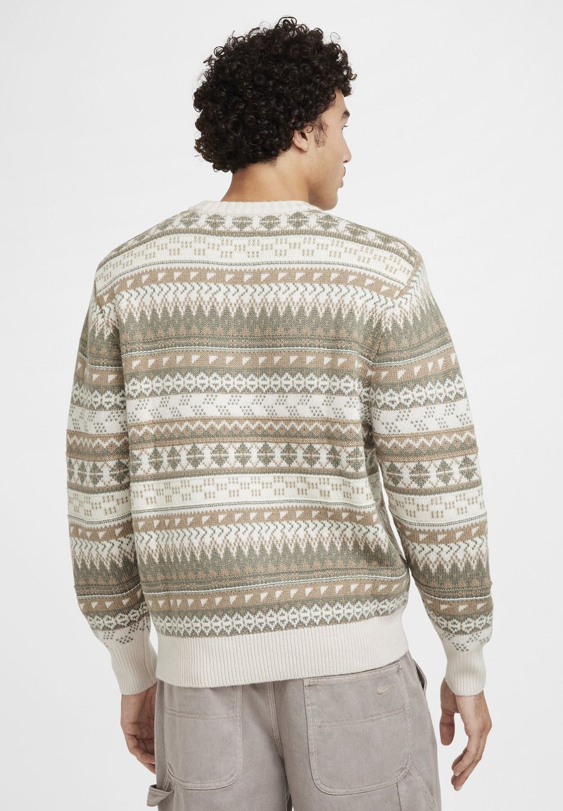 Strickpullover mit einem geometrischen Muster in Erdtönen wie Grün, Beige und Weiß, mit einem gerippten Rundhalsausschnitt und Bündchen.
