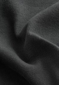 Sötétszürke textil bordázott struktúrával, amelyen lágy szövetredők és finom kötésminta látható. A felület sima és enyhén fényes.