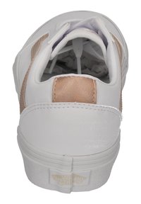 Zapatilla blanca con detalles en oro rosa metálico, punta redonda y collar acolchado. Suela de goma texturizada y detalle del logotipo en el talón.