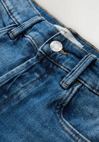 Blaue Jeans aus Denim mit klassischem Fünf-Taschen-Design, silberner Knopfverschluss und kontrastierenden goldenen Nähten. Texturiertes Gewebe mit leichtem Used-Effekt.