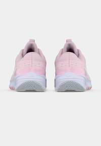 Une paire de baskets d'entraînement rose clair vues de l'arrière, avec des semelles intermédiaires blanches et des semelles extérieures en caoutchouc texturé.