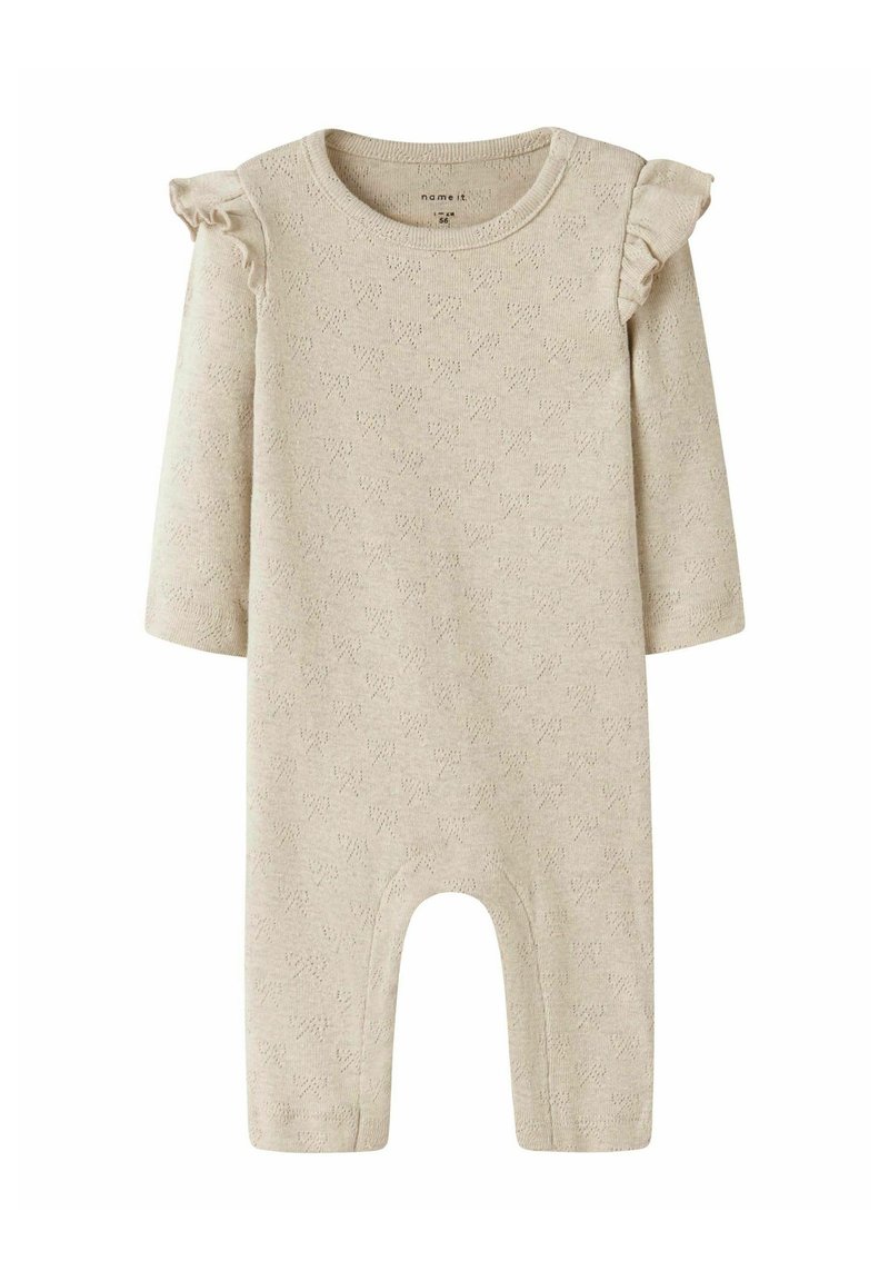 Combinaison en tricot beige avec manches longues, accents d'épaules volants et un motif texturé. Dotée d'un bas ouvert pour un enfilage facile.