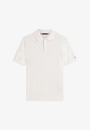 Polo blanc à manches courtes avec motif texturé, col, patte à deux boutons et petit logo sur la manche gauche.