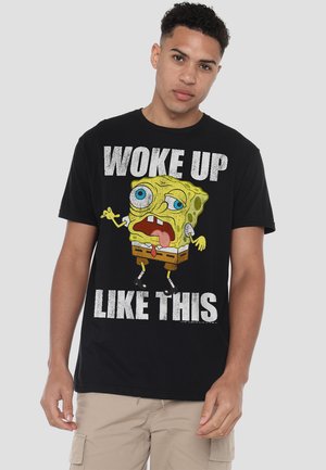 Black cotton t-shirt featuring a graphic of SpongeBob SquarePants and the text "WOKE UP LIKE THIS" in bold, distressed white lettering.