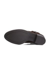 Semelle de chaussure en daim marron avec une semelle extérieure en caoutchouc texturé, présentant des rainures horizontales et une forme arrondie pour une traction et une stabilité optimales.