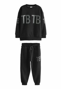 Crna majica i trenirke set u mekom materijalu. Majica ima veliki "TB" logo, a trenirke imaju elastičnu traku u struku i sličan logo.