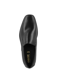 Scarpa nera in pelle senza lacci con punta arrotondata, superficie liscia, dettagli di cucitura discreti e soletta imbottita etichettata "GEOX RESPIRA."