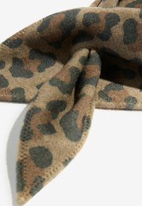Leoparda raksta lakats no mīksta brūna flīsa ar melnām un tumši zaļām nokrāsām. Iezīmējas ar smailu galu un kārtīgu šuvēm ap malām.