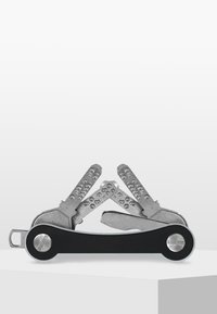 Multitool met zilveren roestvrijstalen gereedschappen en een zwarte plastic handgreep. De gereedschappen omvatten een tang, platte en kruiskop schroevendraaiers, en een mes.