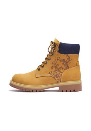 Tan Arbeitsstiefel mit schwarzem gepolstertem Kragen, braunen Schnürsenkeln, dicker Sohle und Drachenmuster an der Seite.