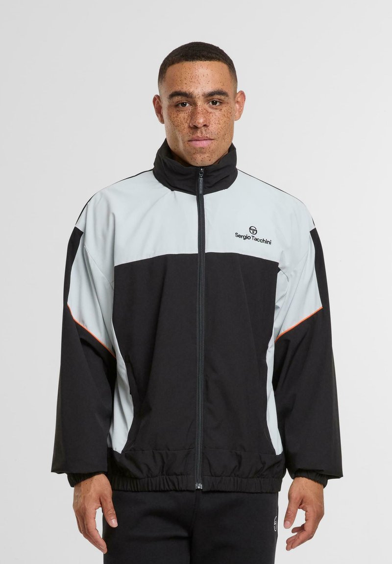 Juodas ir šviesiai mėlynas užtrauktukas striukė su aukštu apykakle, elastingomis rankovėmis ir laisvu siluetu. Logotipas yra išdėstytas ant krūtinės.