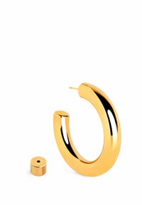 Orecchino a cerchio in oro con una superficie liscia e riflettente e design arrotondato, accompagnato da un piccolo supporto cilindrico.