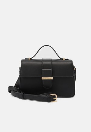 Sac à main en cuir noir avec fermeture à rabat, poignée supérieure, bandoulière réglable et boucle dorée avec accent sur fond uni.