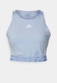 Ljusblått kortat träningslinne med rund hals. Har en vit adidas-logga, sydda detaljer och en strukturerad midjeband.