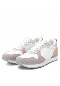 Zapatillas deportivas blancas con acentos de ante gris y rosa, lengüeta de malla y detalle en el talón azul. Cuentan con cordones planos y suelas de goma.