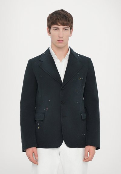 Blazer en coton noir au style ajusté, doté d'un col cranté, de trois boutons et de taches de peinture colorées à l'avant.