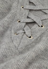 Grauer Strickpullover mit V-Ausschnitt, der mit goldenen Ösen und grauen Bändern verziert ist, und einer weichen, strukturierten Stoffqualität.