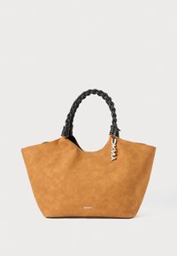 Tan faux-suède tas met een gevlochten zwarte handgreep en een zilveren logo tag. Het heeft een brede opening en een soepele textuur.