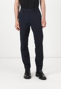 Pantalones azul marino hechos de una tela suave, con un corte ajustado, una silueta elegante y una cintura estándar con trabillas para el cinturón.