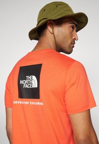 The North Face M SS BOX NSE TEE - Tričko s potlačou - crimson orange/black