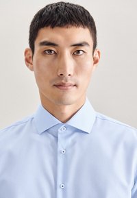 Lichtblauw button-up shirt met een verspreide kraag, soepele textuur en ronde blauwe knopen. Eenvoudig ontwerp, fitted stijl.