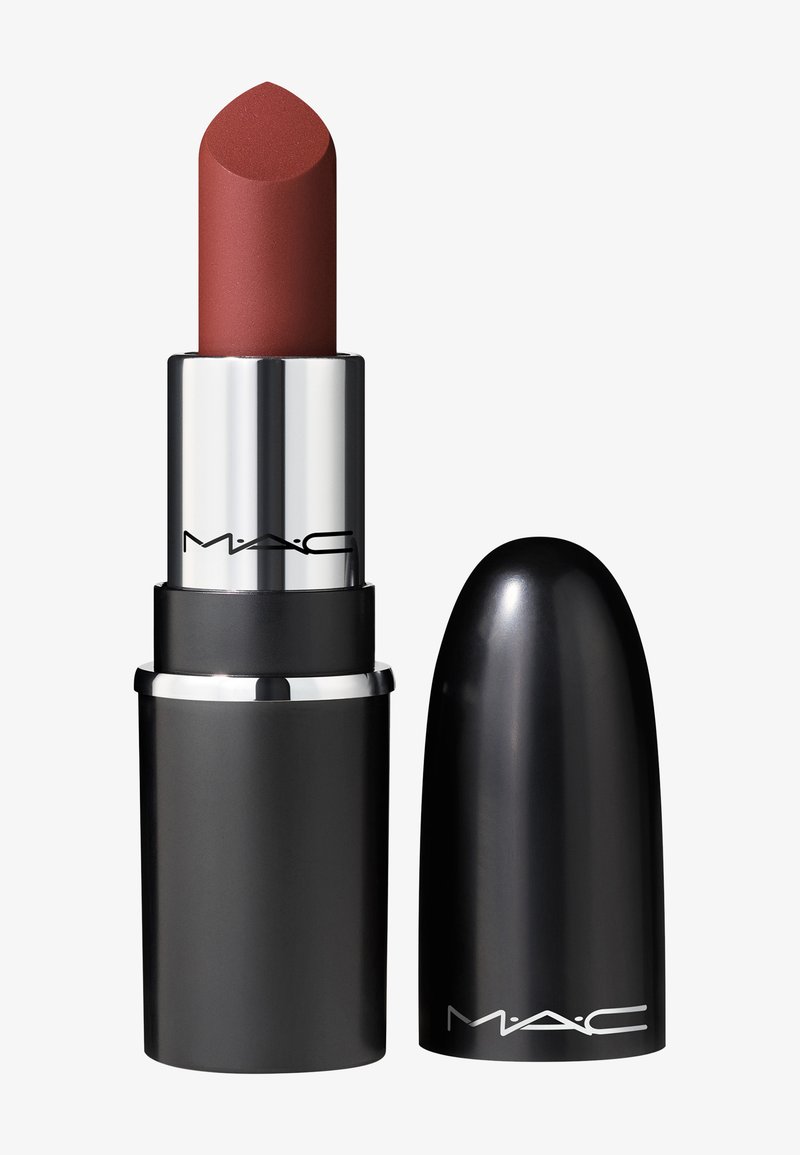 Lipstick i en sort cylindrisk beholder med et metallisk sølvbånd. Produktet har en afrundet spids og er en afdæmpet rødbrun nuance.