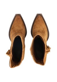 Para beżowych zamszowych botków na obcasie z migdałowym noskiem i chwostami, widocznych z góry na białym tle.