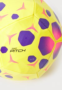 Nike Pitch fodbold, gul med lilla og pink geometriske mønstre, struktureret overflade og synlige syninger. Har logo og størrelse 25/26.