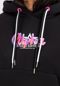 Felpa nera con cappuccio caratterizzata da un colorato logo "Alpha", testi bianchi e lacci con accenti rosa e neri. Tessuto morbido con tasca a marsupio.