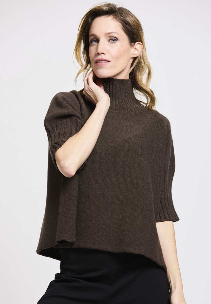 Brown, short-sleeve knit sweater with a high ribbed collar and a relaxed fit. The texture appears soft, with a slight drape at the hem.