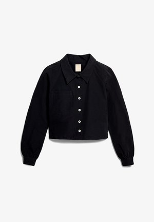 Black cropped shirt with long sleeves, collared neckline, button front, single chest pocket, made of a smooth fabric, featuring white buttons.