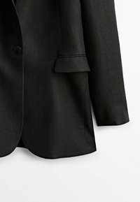 Blazer noir cintré avec un seul bouton, poche à rabat et manches longues, présenté sur un fond blanc.