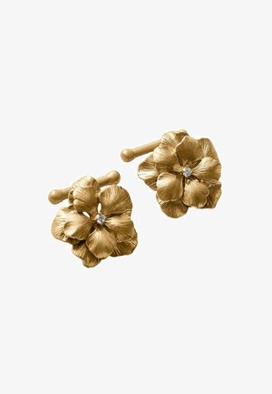 Gemelos florales de tono dorado con pétalos texturizados y una pequeña gema clara en el centro, sobre un fondo blanco.