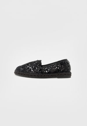 Zapato negro de lentejuelas sin cordones con una suela intermedia de yute tejido. Cuenta con una punta redondeada y un forro interior suave, ofreciendo una superficie texturizada.