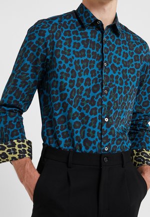 Kleurrijk luipaardprint shirt in blauw en groen, met een knoopsluiting kraag en contrasterende gebloemde manchetten. Soepele stof, getailleerde pasvorm.