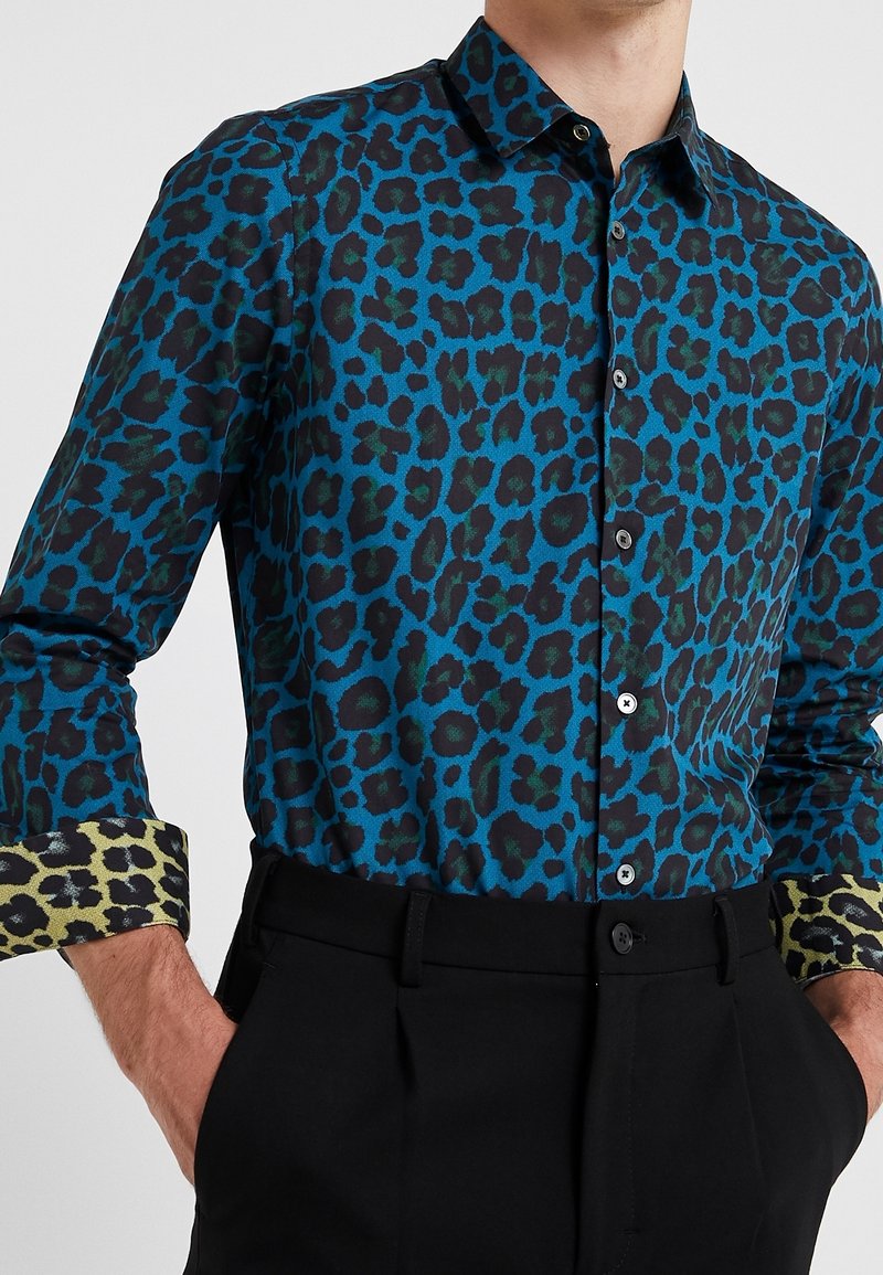Kleurrijk luipaardprint shirt in blauw en groen, met een knoopsluiting kraag en contrasterende gebloemde manchetten. Soepele stof, getailleerde pasvorm.