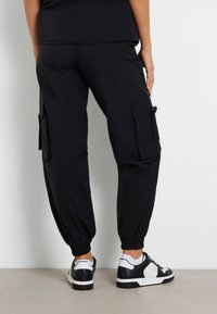 Guess MID WAIST  - Pantaloni cargo - schwarz